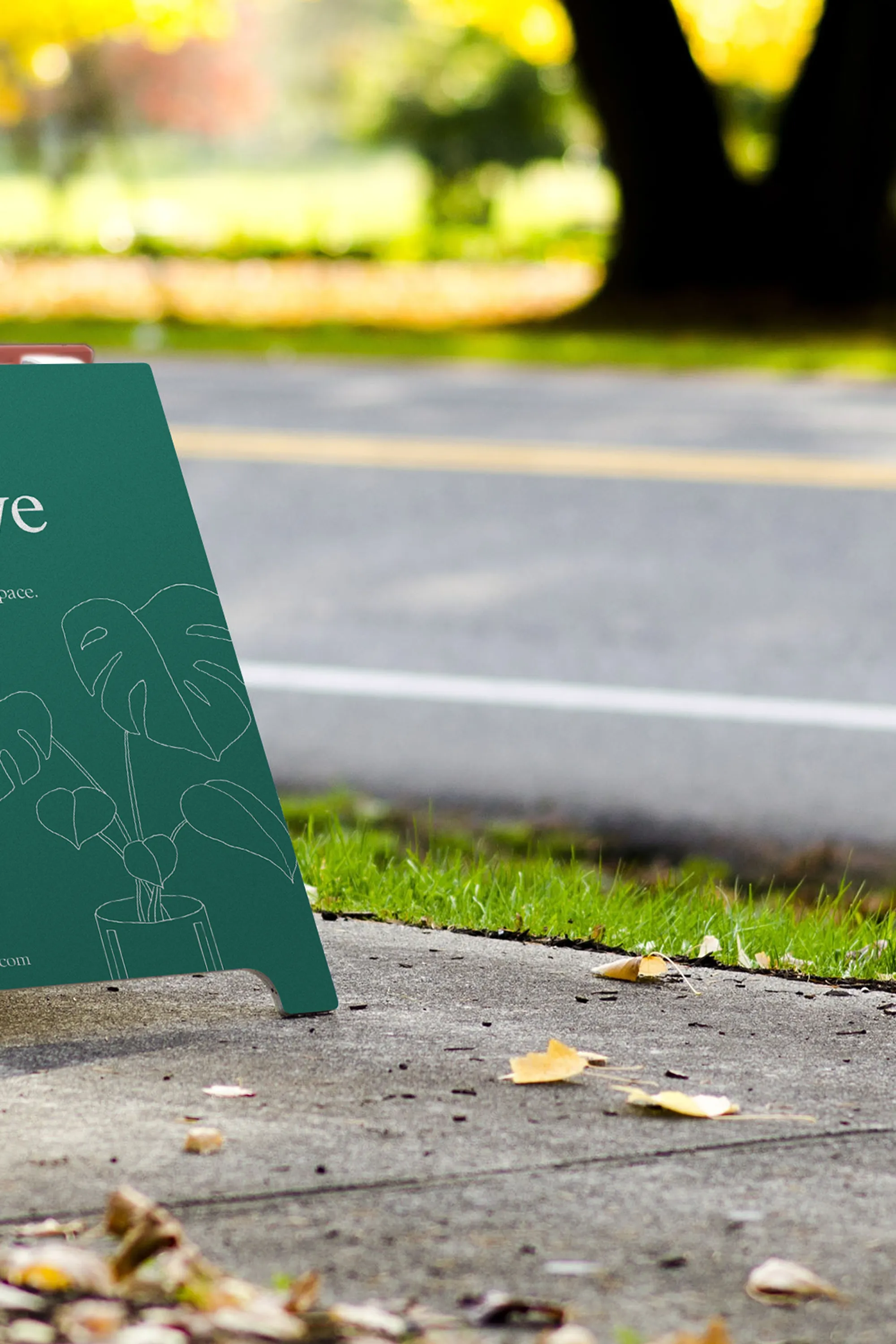 A green Pioneer Collective sign standing on the sidewalk