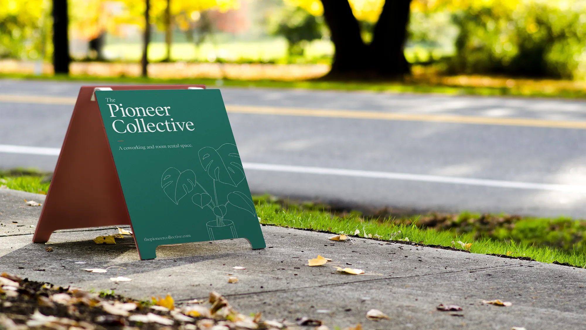 A green Pioneer Collective sign standing on the sidewalk